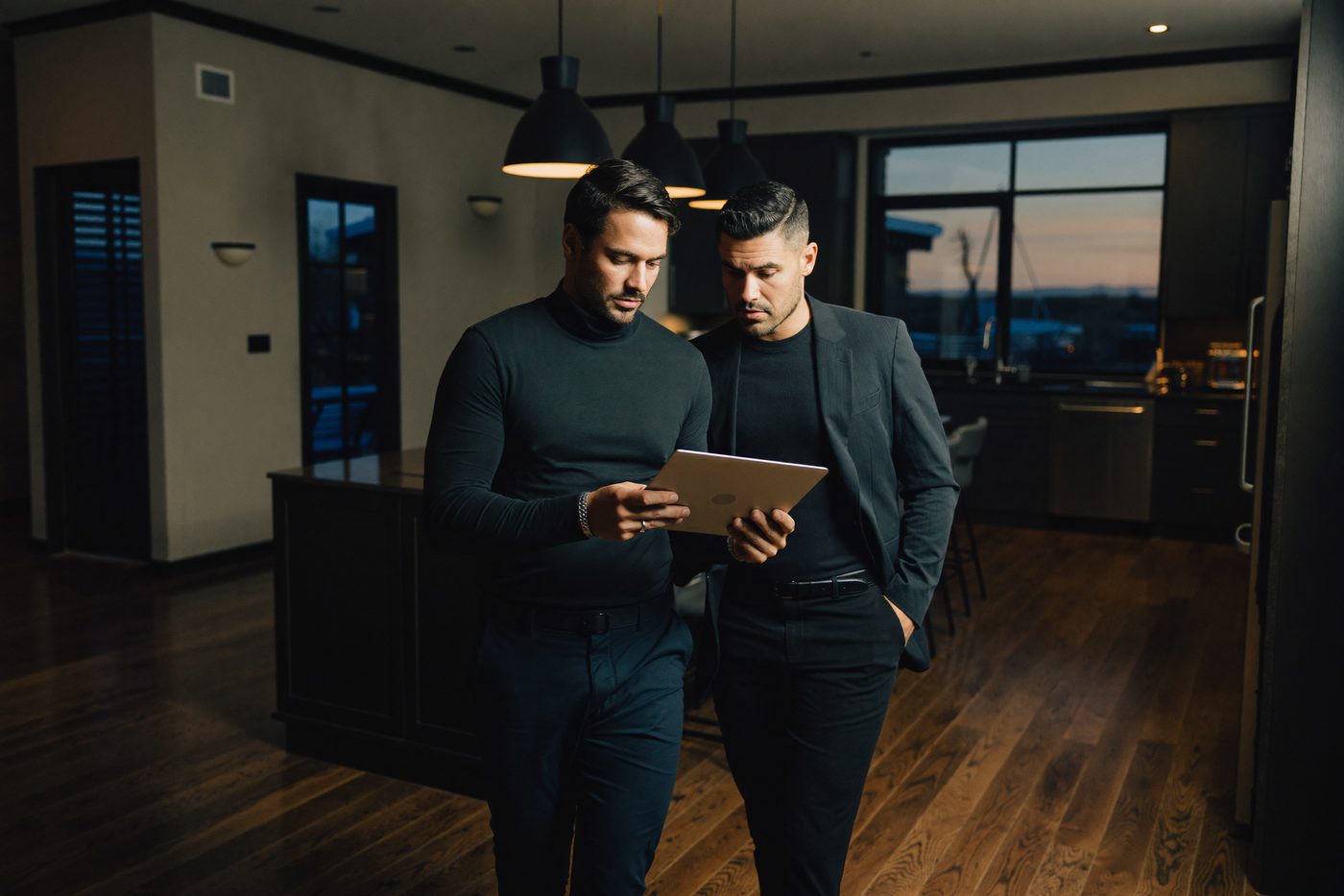 A real estate investor and a property manager review a tablet together in a renovated rental apartment